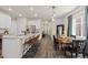 Open living space with kitchen island and seating, dining room, and view into a hallway at 5297 Blue Lunar Ln, Castle Rock, CO 80104