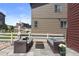 Rear patio with comfortable seating and views of grassy, fenced yards separating neighboring properties at 5297 Blue Lunar Ln, Castle Rock, CO 80104