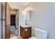 A powder room featuring a wooden vanity, modern lighting, and a neutral color scheme at 1207 S Memphis St, Aurora, CO 80017