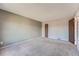 A carpeted bedroom with neutral walls and a door leading to another room, perfect for relaxation at 1207 S Memphis St, Aurora, CO 80017