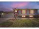Charming two-story home with an attached garage is well-lit at dusk at 1207 S Memphis St, Aurora, CO 80017