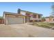 Charming two-story home featuring a well-maintained front yard and an attached two-car garage at 1207 S Memphis St, Aurora, CO 80017