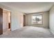 Spacious main bedroom featuring neutral carpeting, a large window, and access to the en-suite bathroom at 1207 S Memphis St, Aurora, CO 80017