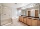 Bathroom featuring double sinks, a large mirror, and a walk-in shower at 4850 Bluegate Ln, Highlands Ranch, CO 80130