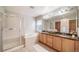 Bathroom featuring double sink vanity, soaking tub and walk-in shower with glass door at 4850 Bluegate Ln, Highlands Ranch, CO 80130