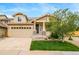 Tan two-story home features a two-car garage, covered porch, and well-maintained lawn at 4850 Bluegate Ln, Highlands Ranch, CO 80130