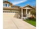 Inviting home with a two-car garage, stone accents and green lawn at 4850 Bluegate Ln, Highlands Ranch, CO 80130