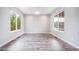 Bright, open living room features wood-look floors and large windows at 4850 Bluegate Ln, Highlands Ranch, CO 80130