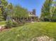 The brick home with a lush green backyard features a back patio complete with outdoor furniture and mature trees at 9931 E Ida Pl, Greenwood Village, CO 80111