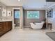 Bright bathroom with a modern soaking tub, dual windows, and wooden cabinetry at 9931 E Ida Pl, Greenwood Village, CO 80111