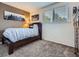 This cozy bedroom has neutral paint, carpet, and window bringing in light to create a welcoming retreat at 9931 E Ida Pl, Greenwood Village, CO 80111