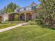 Charming brick home with a well-manicured lawn and covered porch at 9931 E Ida Pl, Greenwood Village, CO 80111