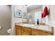 A bathroom featuring a sink with a marble countertop, wooden cabinets, and colorful wall decor at 7567 Parkview Mtn, Littleton, CO 80127