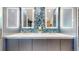 Bathroom vanity with double sinks, white countertop, blue mosaic tile backsplash, and illuminated mirrors at 7567 Parkview Mtn, Littleton, CO 80127