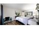 A bright bedroom features a comfy bed, tv atop a dark wood dresser, hard wood floors, and closet with mirrored doors at 7567 Parkview Mtn, Littleton, CO 80127