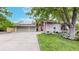 Charming home featuring a well-manicured lawn, mature trees, and a welcoming driveway leading to a spacious garage at 7567 Parkview Mtn, Littleton, CO 80127
