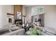 Spacious living room showcasing a floor-to-ceiling fireplace, large windows, and stylish neutral furniture at 7567 Parkview Mtn, Littleton, CO 80127