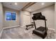 Finished basement with a treadmill, weight bench, and natural light from the window at 6652 W Asbury Pl, Lakewood, CO 80227