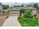 Charming home featuring a two-car garage and professionally landscaped front yard with mature trees at 6652 W Asbury Pl, Lakewood, CO 80227