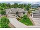 Well-manicured home featuring mature trees, a two car garage, and professional landscaping at 6652 W Asbury Pl, Lakewood, CO 80227