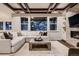 Open living room with coffered ceilings, stone fireplace, built-in shelving, and large windows at 6652 W Asbury Pl, Lakewood, CO 80227