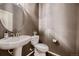 Stylish powder room featuring a pedestal sink, round mirror, decorative walls, and modern fixtures at 6652 W Asbury Pl, Lakewood, CO 80227