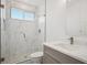 Modern bathroom with white marble tile, glass shower, and a sleek vanity at 49601 E 56Th Ave, Bennett, CO 80102