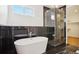 Luxurious bathroom features a soaking tub, black marble accents, and a glass-enclosed shower at 49601 E 56Th Ave, Bennett, CO 80102