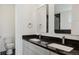 Modern bathroom featuring dual sinks, granite countertops, and framed mirrors at 49601 E 56Th Ave, Bennett, CO 80102