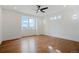 Bright bedroom with hardwood floors, a ceiling fan, and plenty of natural light from the large window at 49601 E 56Th Ave, Bennett, CO 80102
