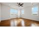 Bright bedroom featuring hardwood floors, a ceiling fan, three large windows, and recessed lighting at 49601 E 56Th Ave, Bennett, CO 80102