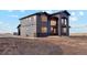 Modern two-story home features a stylish gray and black exterior with a unique arched entryway at 49601 E 56Th Ave, Bennett, CO 80102