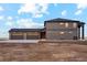 Modern two-story home features a large three car garage, a dark gray facade, and manicured lawn at 49601 E 56Th Ave, Bennett, CO 80102