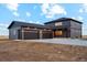 Modern two-story home features a large three car garage, a dark gray facade, and manicured lawn at 49601 E 56Th Ave, Bennett, CO 80102
