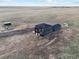 Aerial view of a modern two-story home with black siding and trim surrounded by a vast open field at 49601 E 56Th Ave, Bennett, CO 80102