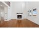 Sunlit living room showcases tall ceilings, a cozy fireplace, and rich hardwood flooring at 49601 E 56Th Ave, Bennett, CO 80102