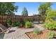 Lush backyard garden featuring mature trees, gravel pathway, and raised garden beds for green and natural beauty at 815 S Gaylord St, Denver, CO 80209