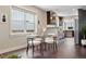 Modern dining area with a glass table, four chairs, and an open floor plan into the kitchen at 815 S Gaylord St, Denver, CO 80209