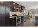 Well-equipped kitchen with stainless steel appliances, dark cabinets, and an open layout for easy flow at 815 S Gaylord St, Denver, CO 80209