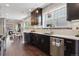 Modern kitchen with dark cabinets, stainless steel appliances, and an open concept to the dining area at 815 S Gaylord St, Denver, CO 80209