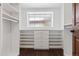 A spacious walk-in closet with custom shelving, drawers, and a window offering natural light at 815 S Gaylord St, Denver, CO 80209