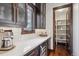 Kitchen featuring white countertops, dark wood cabinets, a wine cooler, and pantry with ample shelving at 230 Hudson St, Denver, CO 80220