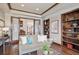 Stylish living room featuring a cozy couch, glass paneled door, hardwood floors and custom built in shelving at 230 Hudson St, Denver, CO 80220