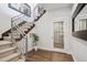 Modern staircase with sleek metal railings and a unique wine cellar behind a glass door, adding a touch of luxury at 230 Hudson St, Denver, CO 80220