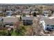 An aerial view displays a home with a patio, bordered by a grassy yard and mature trees within a neighborhood at 18995 E Bellisario Creek Pl, Parker, CO 80134
