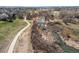 Scenic aerial view of a paved path alongside a serene river, surrounded by natural landscape and open fields at 18995 E Bellisario Creek Pl, Parker, CO 80134