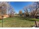 Lush backyard with green grass and mature trees, offering a serene and private outdoor space at 18995 E Bellisario Creek Pl, Parker, CO 80134