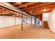 Unfinished basement with visible ceiling beams, carpet flooring, and white-painted walls, offering potential for customization at 18995 E Bellisario Creek Pl, Parker, CO 80134