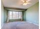 Cozy bedroom with neutral carpet, a ceiling fan, and a large window bringing in natural light at 18995 E Bellisario Creek Pl, Parker, CO 80134