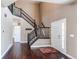 Inviting foyer with dark wood floors, a staircase with wrought iron railings, and a white front door at 18995 E Bellisario Creek Pl, Parker, CO 80134